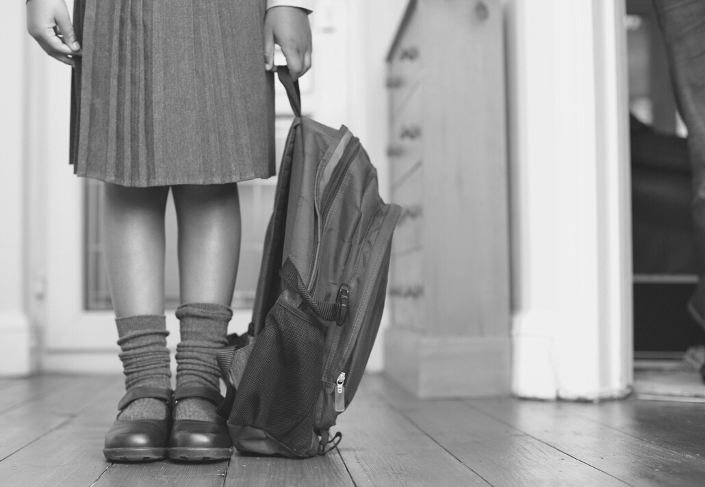 Girl in school uniform holding school bag